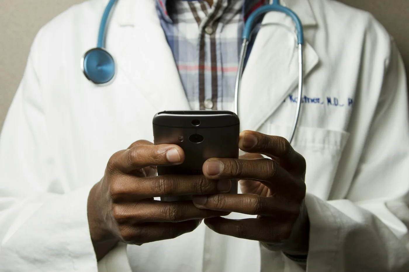 Clinician using a phone while wearing a stethoscope